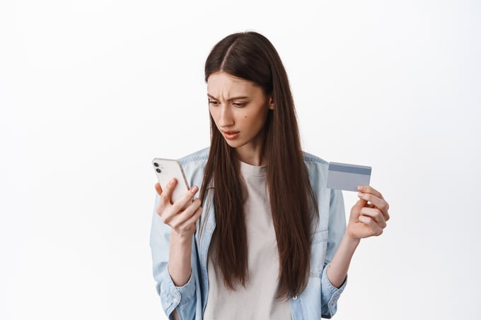 Person looking at credit card showing a sense of alertness and concern