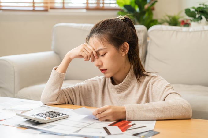 Young woman looking concerned while reviewing a credit card bill or statement